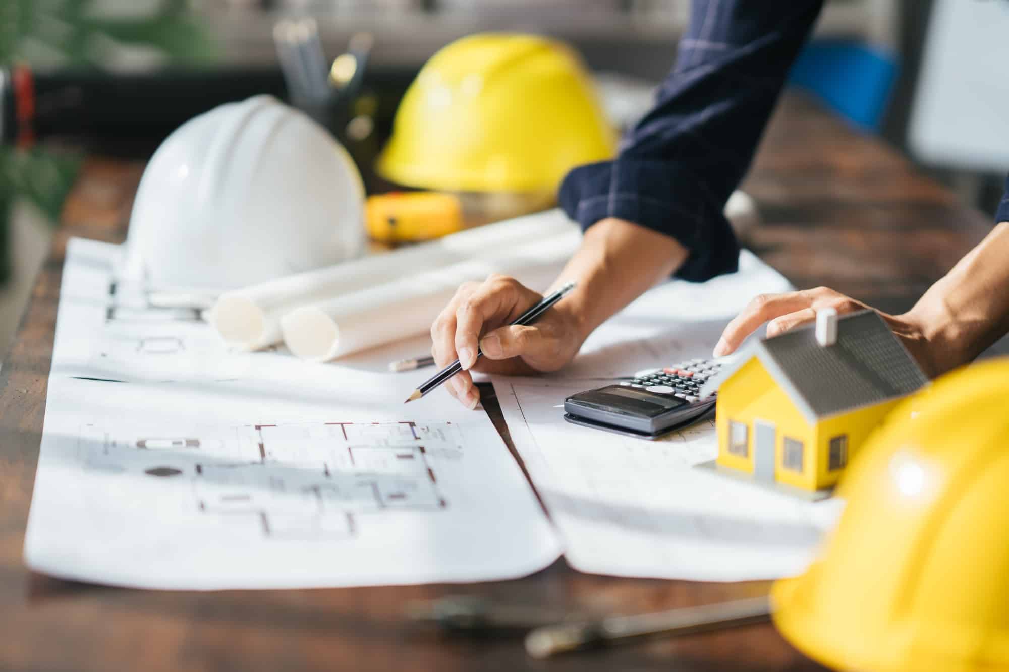 Cropped shot of Professional architect working at his desk, measuring and estimating the house proje